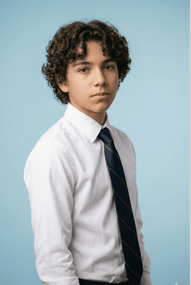 Original student portrait against a light blue backdrop before background removal.